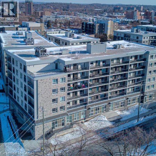 Apartment complex with snow on the ground and trees.