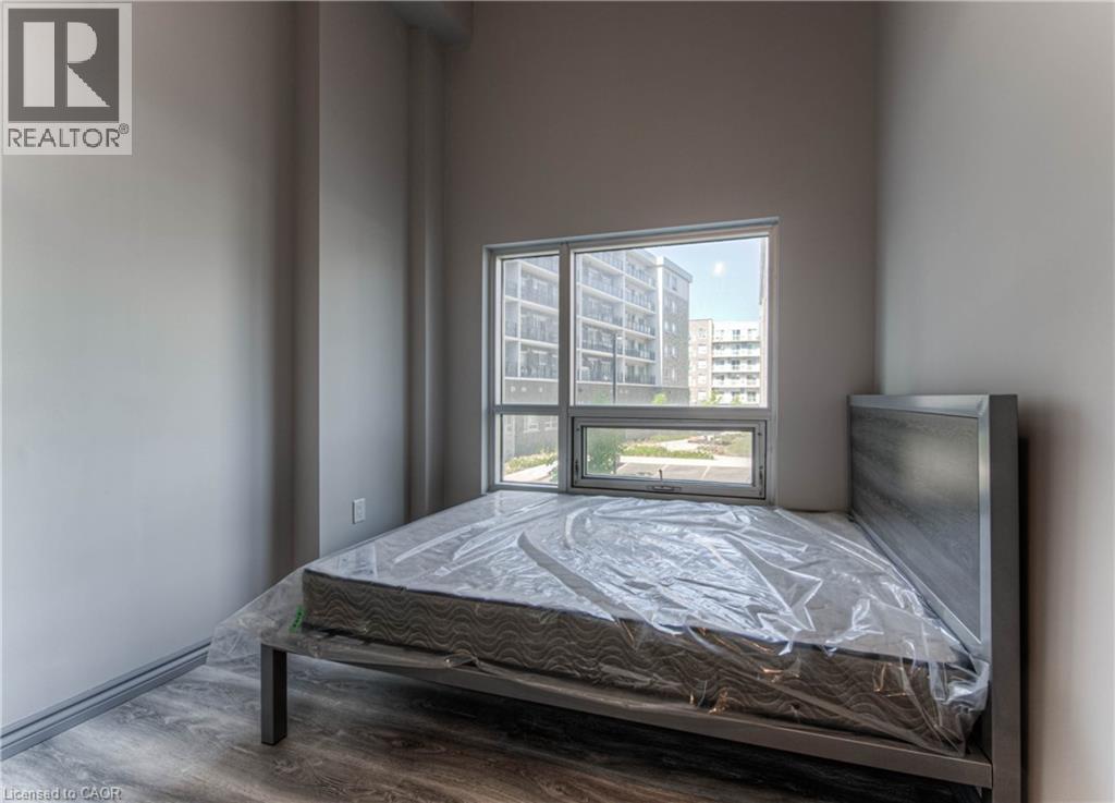 A bedroom with a bed, a window, and a view of a building outside.