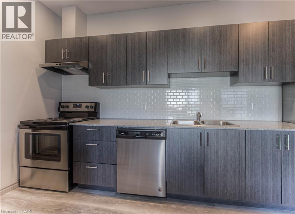 A modern kitchen with dark wood cabinets and stainless steel appliances.