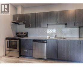A modern kitchen with dark wood cabinets and stainless steel appliances.