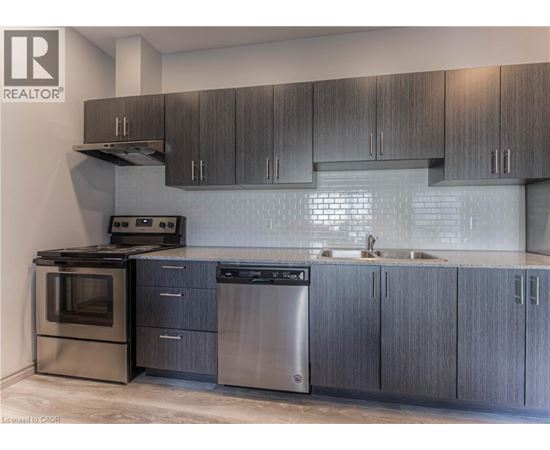 A modern kitchen with dark wood cabinets and stainless steel appliances.