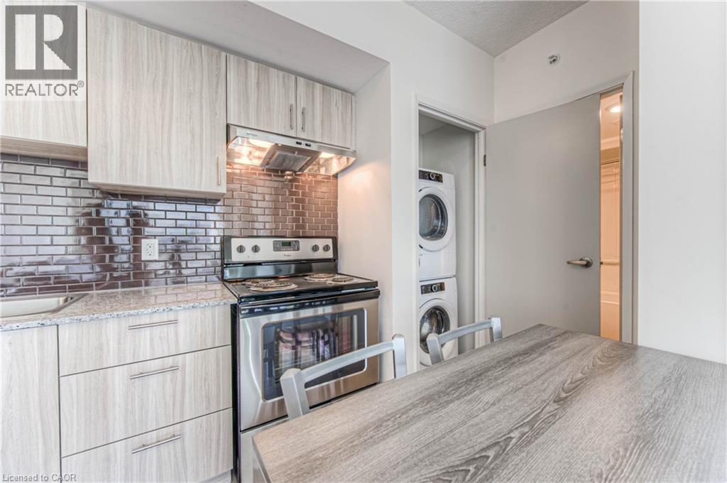 A modern kitchen with a stove top oven and a washing machine built into the cabinetry.