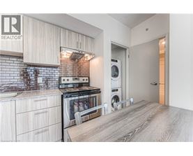 A modern kitchen with a stove top oven and a washing machine built into the cabinetry.