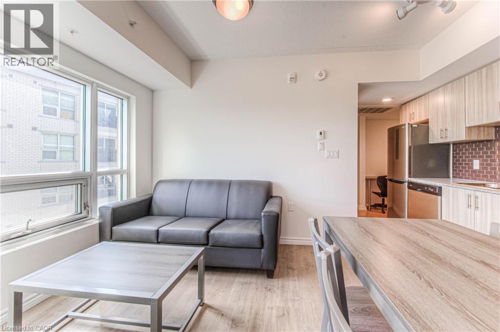 A modern living room with a grey sofa and a wooden dining table.
