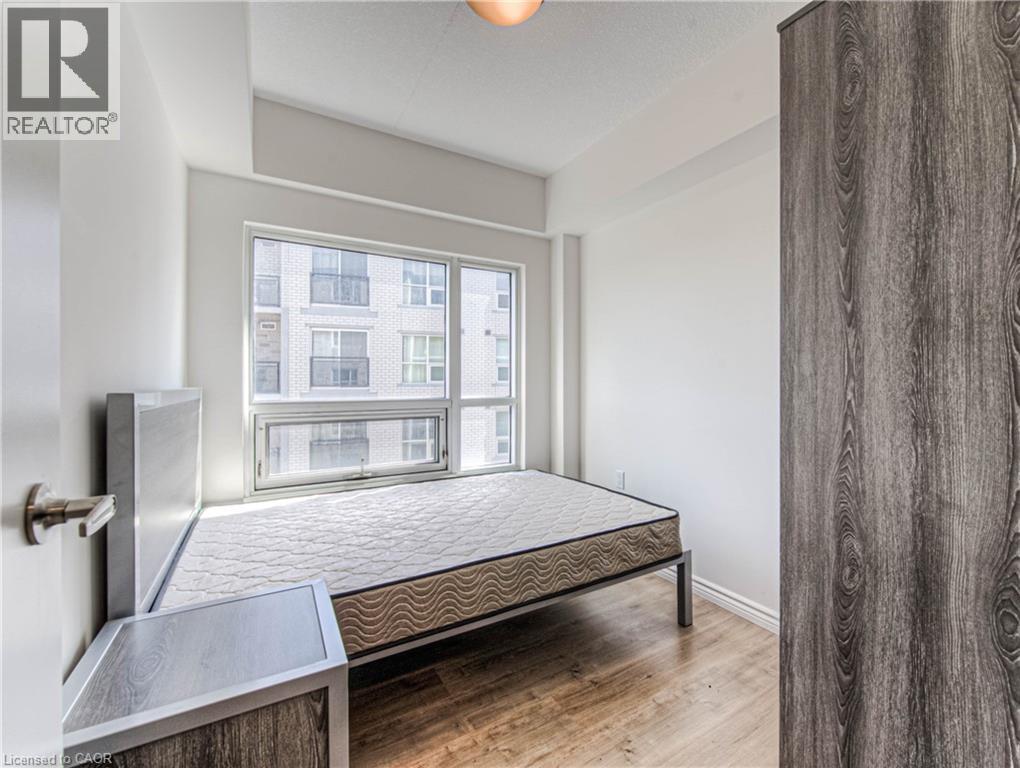 A bedroom with a large bed and a window overlooking a building.