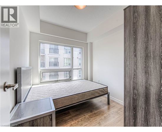 A bedroom with a large bed and a window overlooking a building.