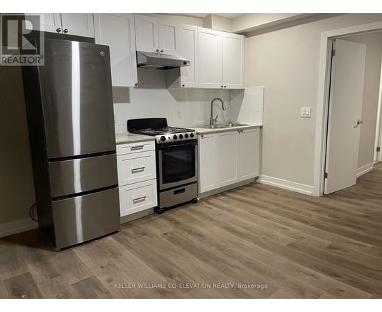 A kitchen with a stainless steel refrigerator, oven, and cabinets.