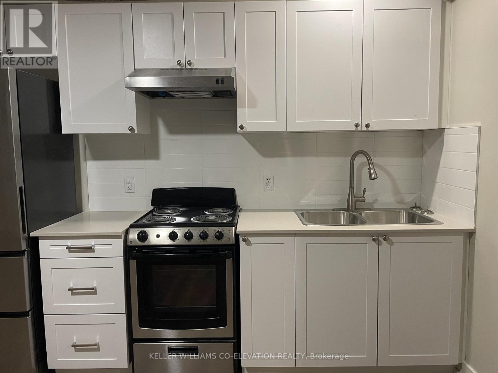 A white kitchen with a stove and cabinets.