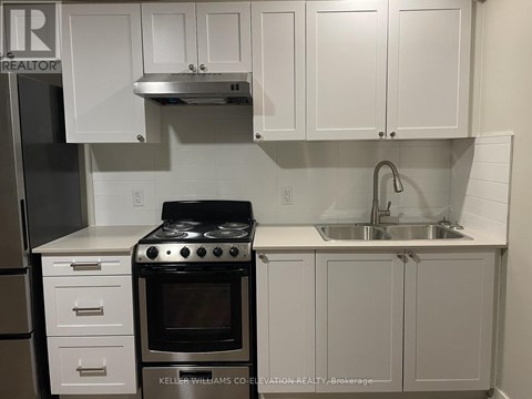 A white kitchen with a stove and cabinets.