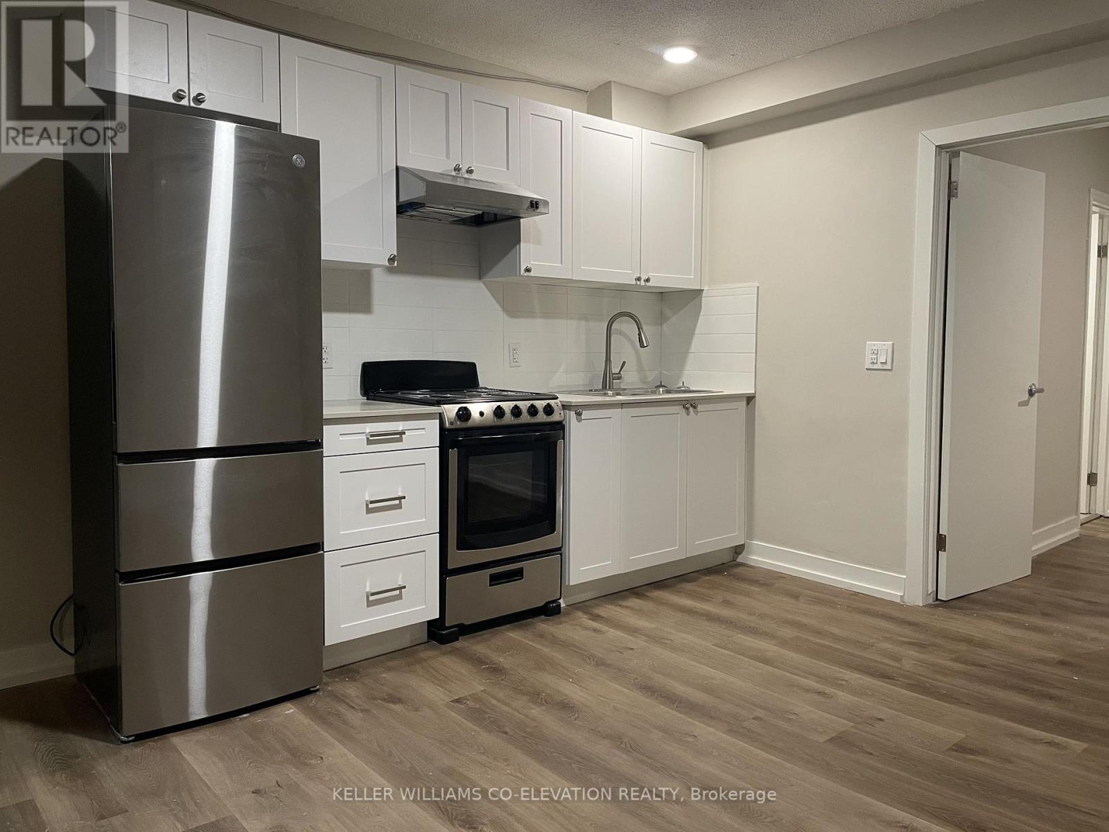 A modern kitchen with a stainless steel refrigerator, oven, and cabinets.
