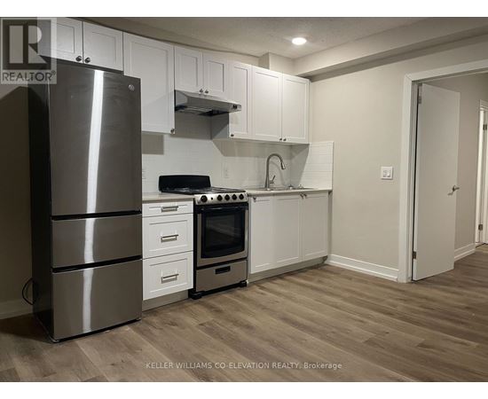 A modern kitchen with a stainless steel refrigerator, oven, and cabinets.