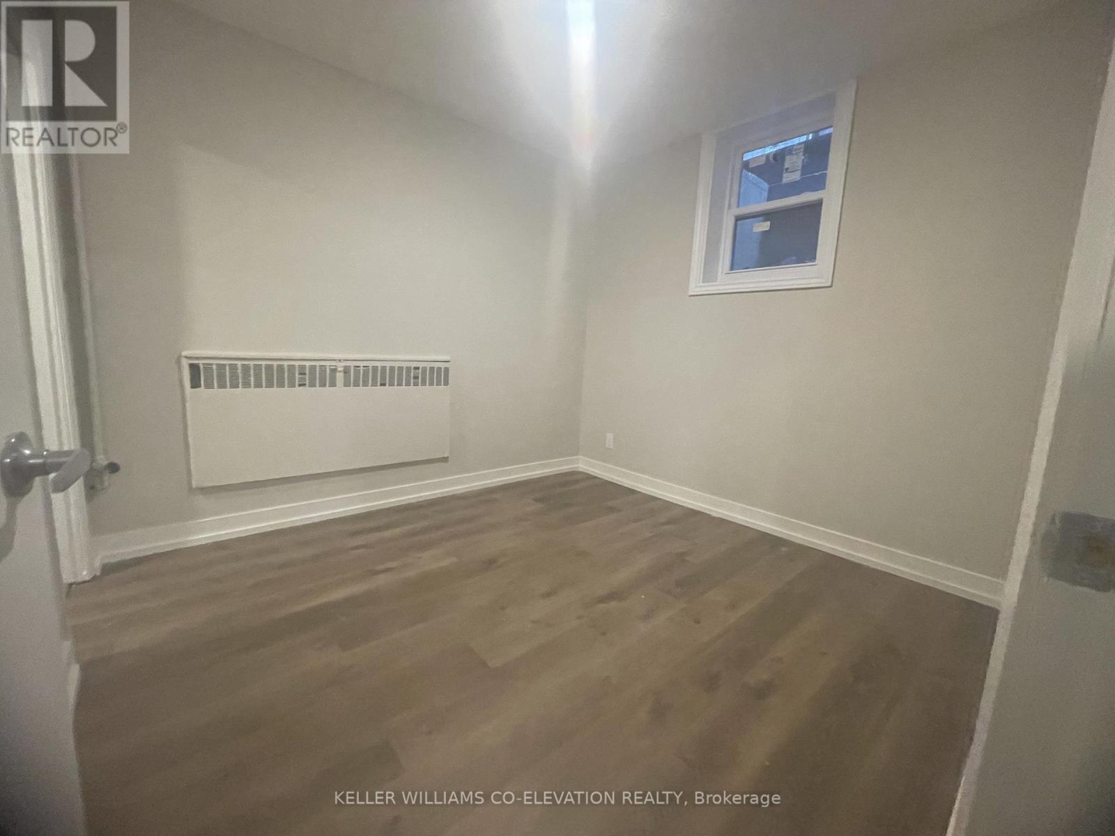 A room with a window and a radiator on the wall.