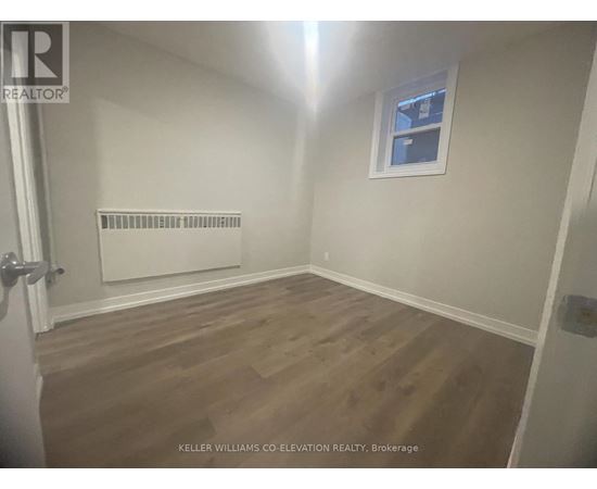 A room with a window and a radiator on the wall.