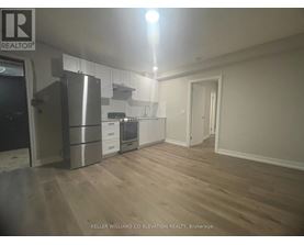 A kitchen with a refrigerator, oven, and cabinets.