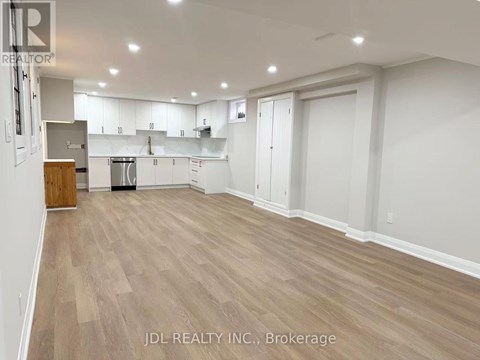 A spacious kitchen with white cabinets and a wooden island.