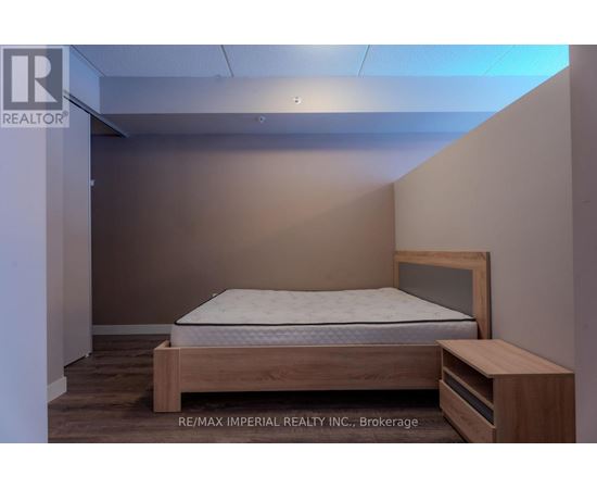 A bedroom with a bed and a nightstand.