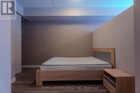A bedroom with a bed and a nightstand.