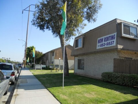 A building with a sign that says "Now Renting" and a phone number.