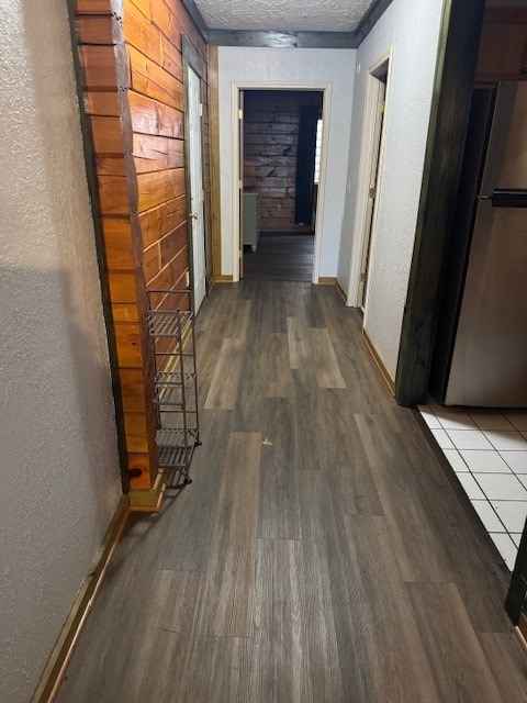 A long hallway with a wooden floor and a brick wall in the background.
