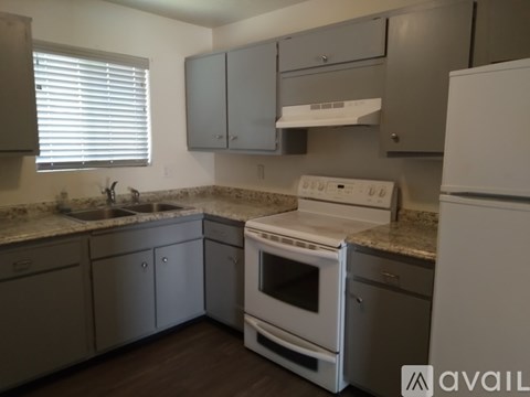 A kitchen with a white oven and refrigerator.