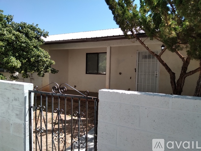 A house with a white fence and a tree in front.