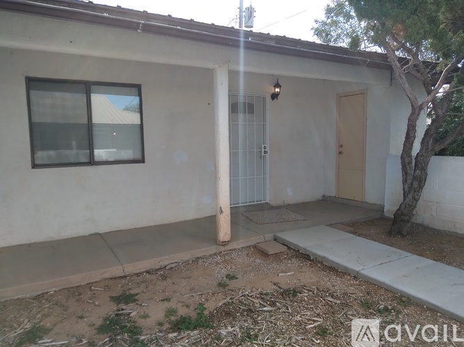 A house with a brown door and a tree in front.