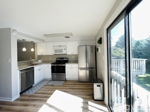 A modern kitchen with white cabinets and stainless steel appliances.