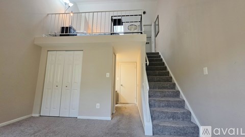 A spacious room with a staircase leading to the upper floor.
