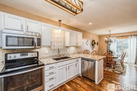 A kitchen with white cabinets and a black stove top oven.