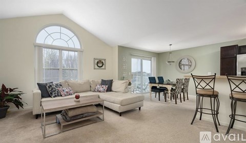 A living room with a white couch and a large window.