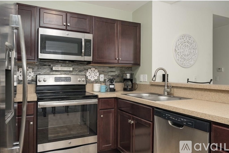 A kitchen with brown cabinets and a stainless steel refrigerator.