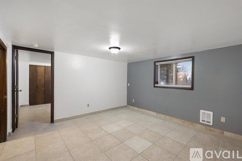 A room with a tiled floor and a window with blinds.