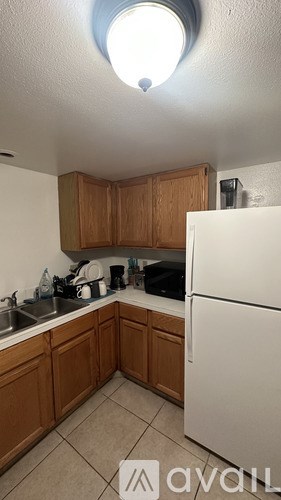 A kitchen with wooden cabinets and a white refrigerator.