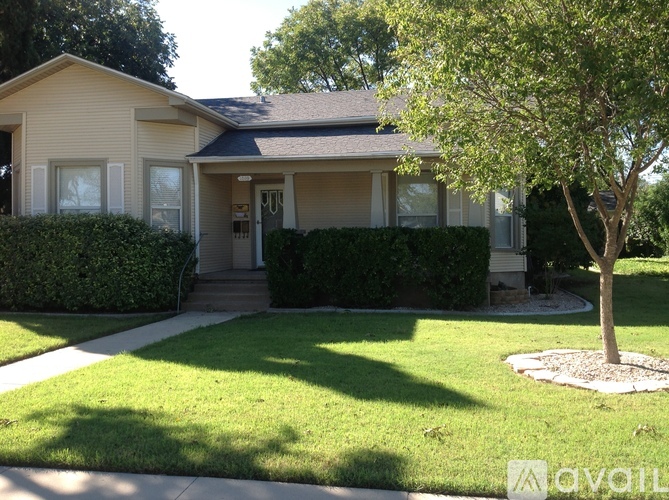 A house with a front yard and a tree.