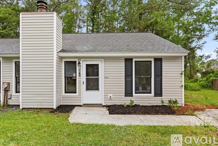 A house with a grey siding and a white door is for sale.