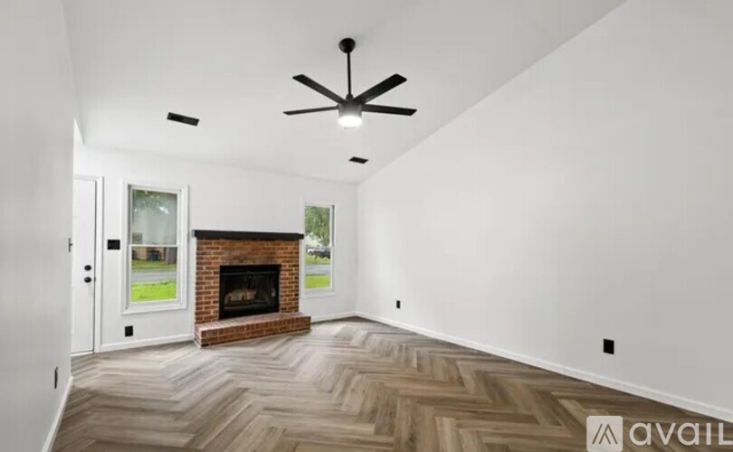 A room with a fireplace and a ceiling fan.