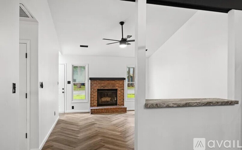 A modern living room with a fireplace and a ceiling fan.
