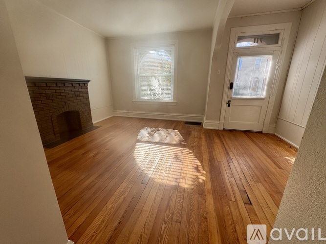 A room with wooden floors and a fireplace.