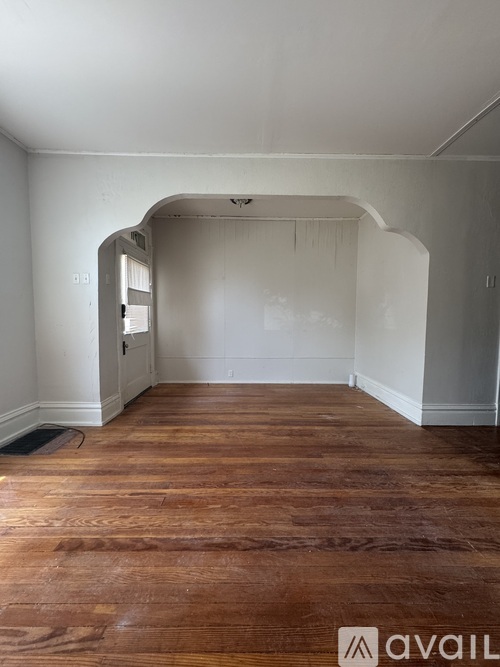 A room with wooden flooring and white walls.