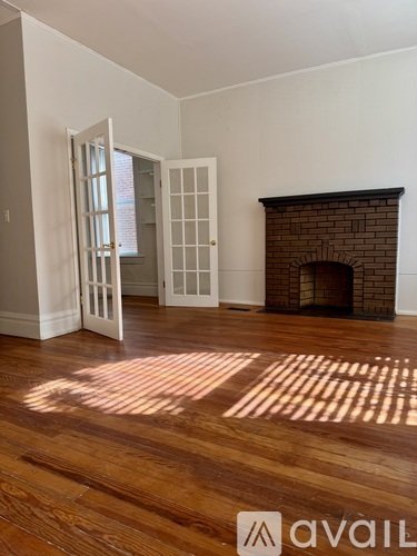 A room with a fireplace and wooden floors.