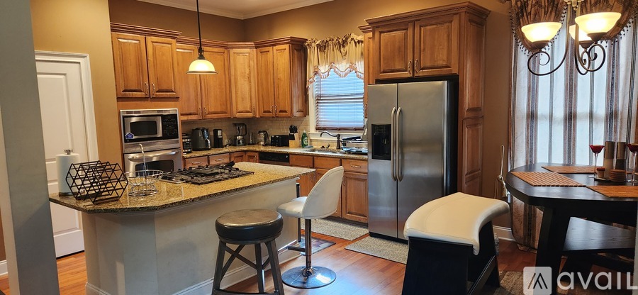 A kitchen with a granite counter top and a refrigerator.