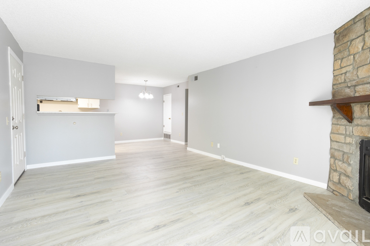 A spacious living room with a fireplace and a wooden floor.