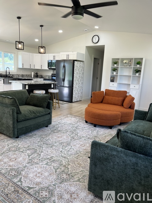 A living room with a grey rug and a green couch.