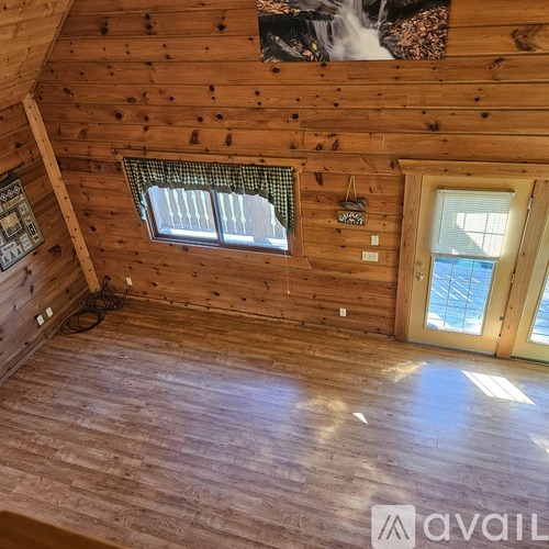A wooden room with a window and a door.