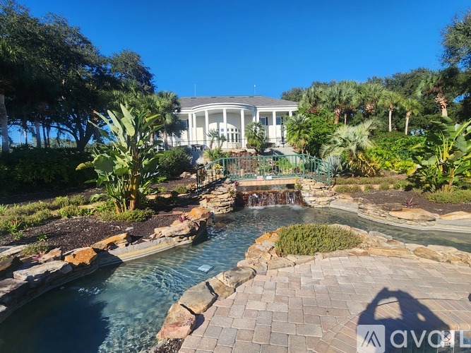 A house with a pool and waterfall in the backyard.