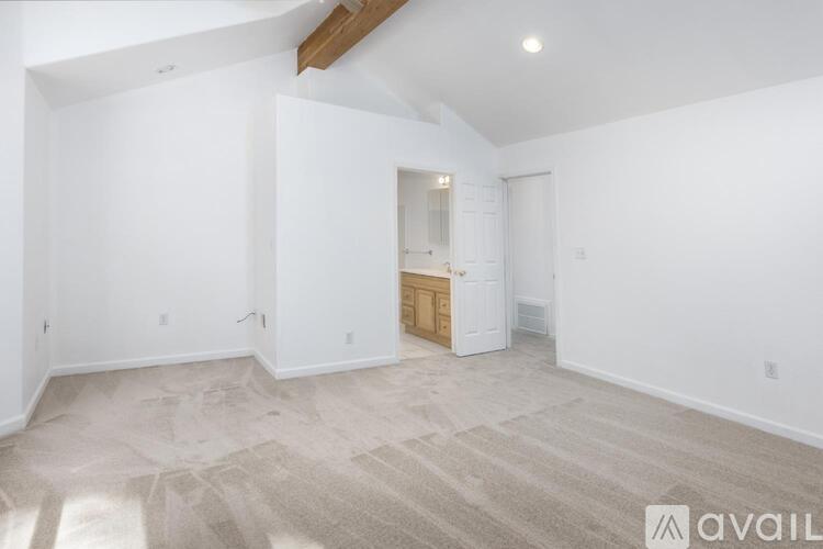 A spacious room with a carpeted floor and a wooden cabinet.