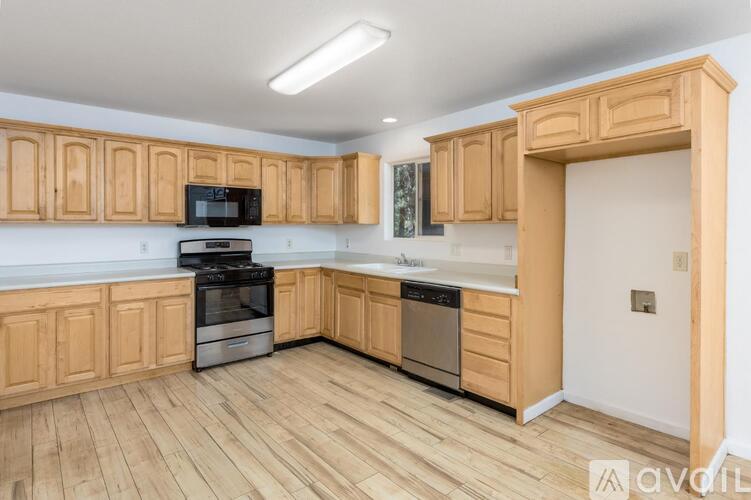 A kitchen with wooden cabinets and appliances.