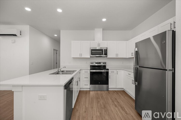 A modern kitchen with white cabinets and stainless steel appliances.