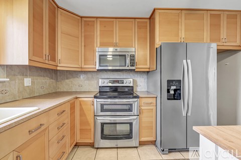 A kitchen with wooden cabinets and stainless steel appliances.
