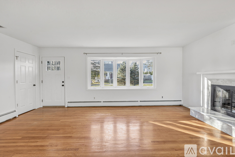 A spacious room with a fireplace and a large window.